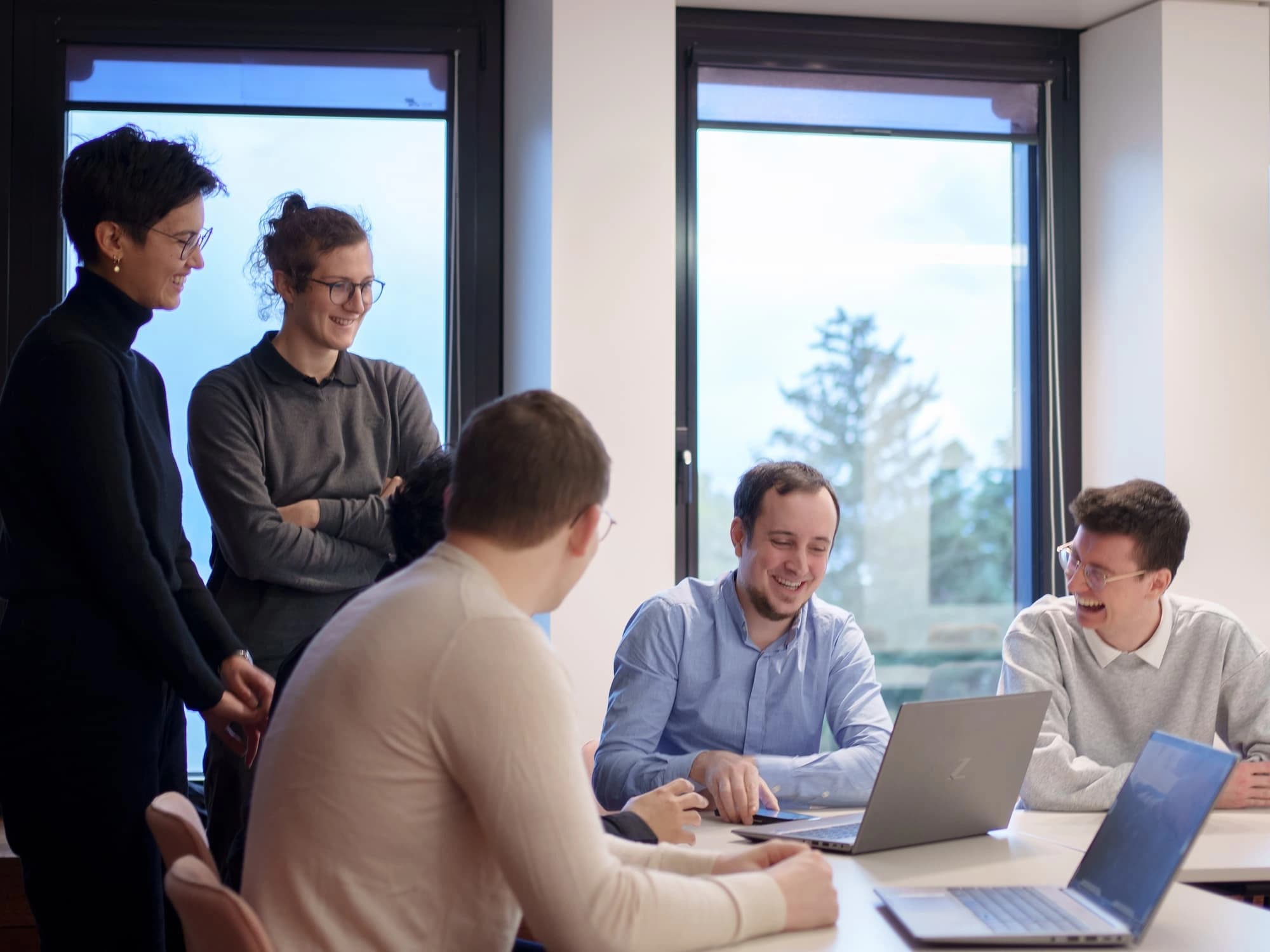 TrustID employees brainstorming ideas in a collaborative work environment, exchanging insights to drive innovation